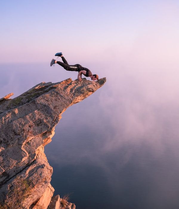Man performing a strength and balance exercise outdoors at sunrise.